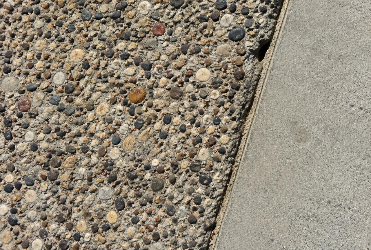 Exposed aggregate concrete surface beside a smooth concrete border